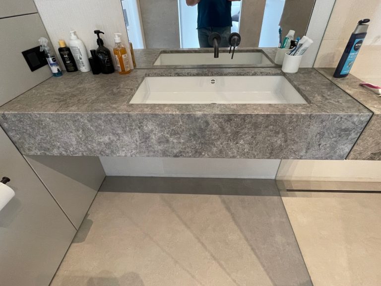 Zdjęcie przedstawia piękny blat łazienkowy z zlewozmywakiem i lustrem